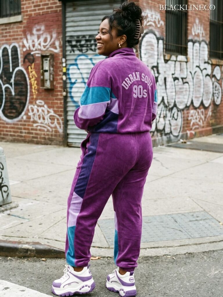 Plus-size Black woman in a matching 90s tracksuit with claw clip and gold hoops