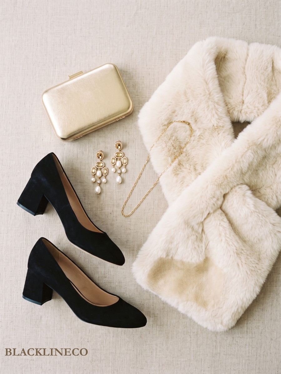 flat lay of black block heels, gold clutch, drop earrings, necklace, and faux fur stole
