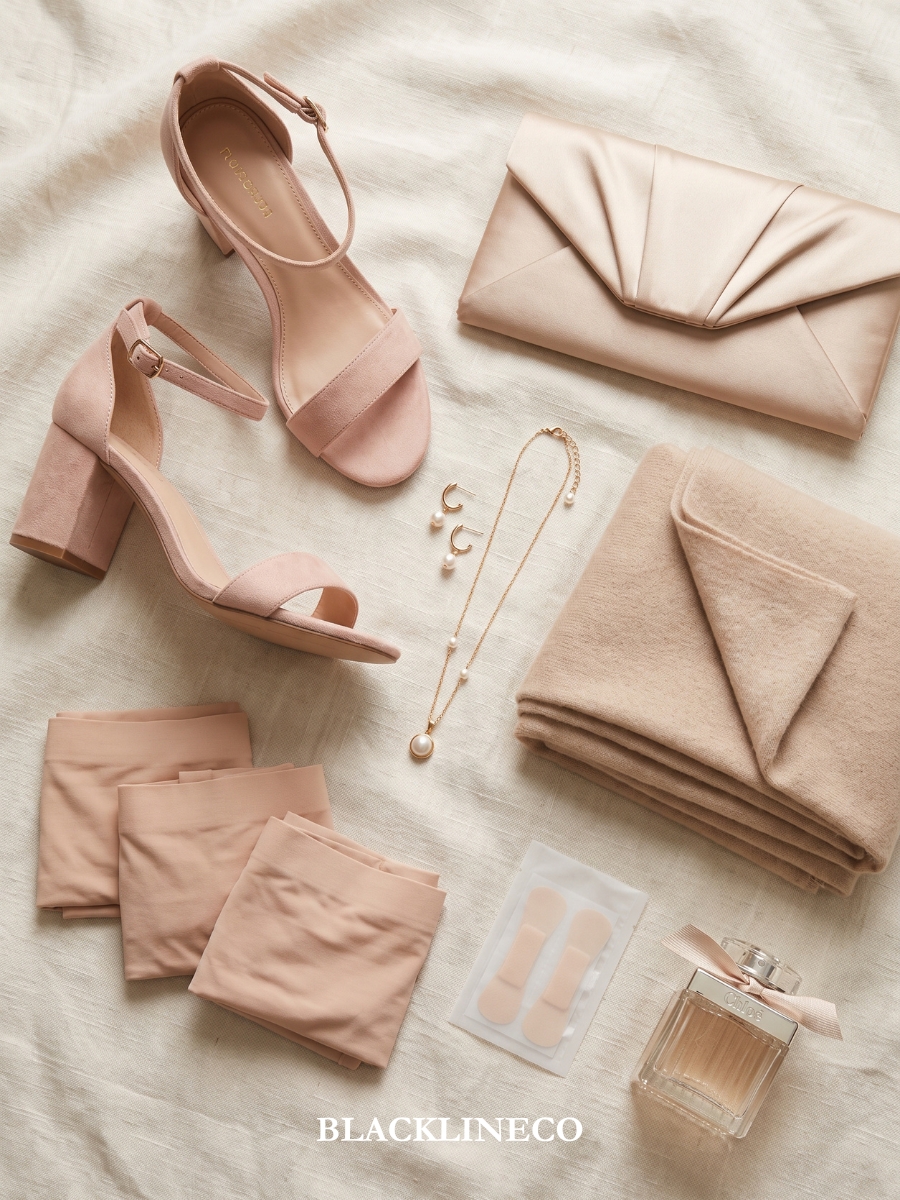 Wedding guest styling essentials including shoes, clutch, jewelry, wrap, and undergarments